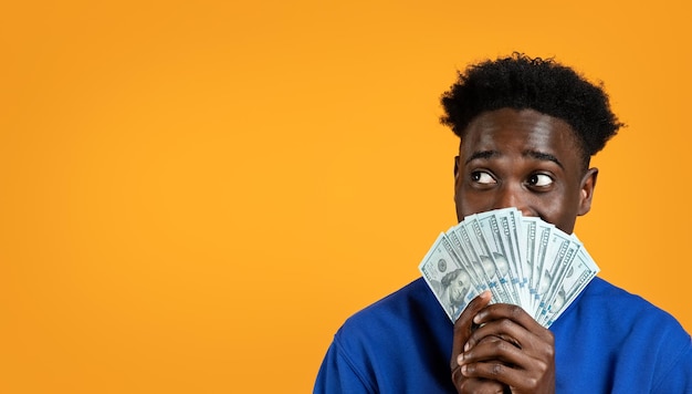 Афроамериканский молодой человек с наличными деньгами копирует пространство