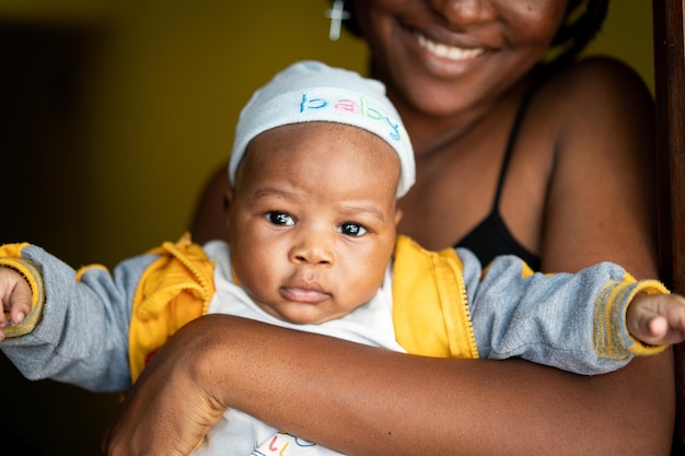 African American young mother holding her baby indoors