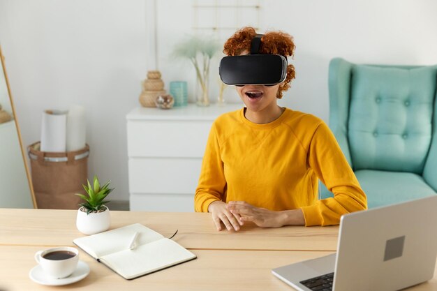 African american young woman wearing using virtual reality metaverse vr glasses headset at home girl