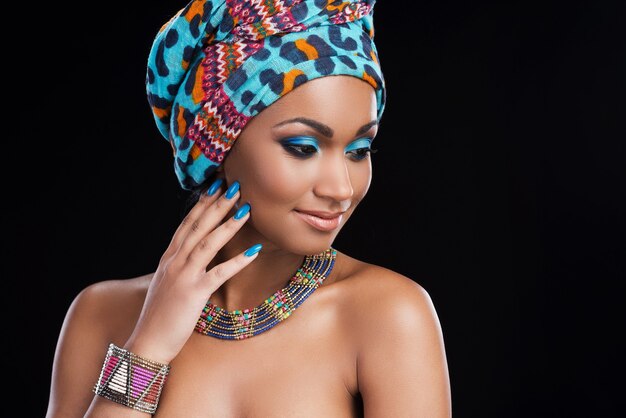 African beauty. Beautiful African woman wearing a headscarf and necklace and looking away 