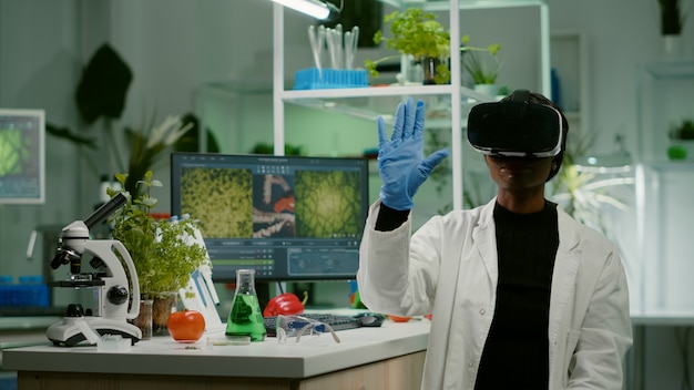 African biologist researcher with virtual reality headset researching new genetic experiment