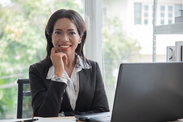 Photo african business woman working in office using computer and look camera