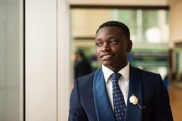 African businessman looking through window