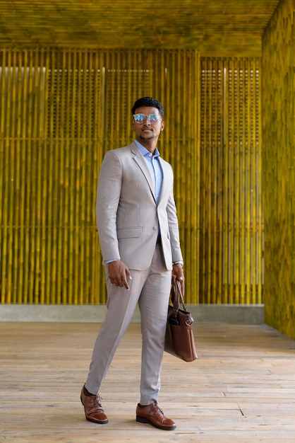 African businessman outdoors walking and looking stylish and cool full length shot