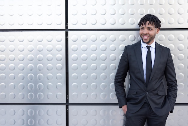 African businessman in suit at silver wall