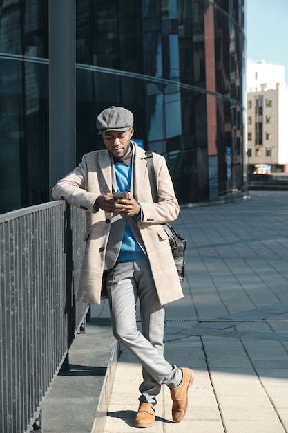 African businessman using smart phone while standing in the city