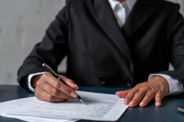 African businesswoman writing at table close up