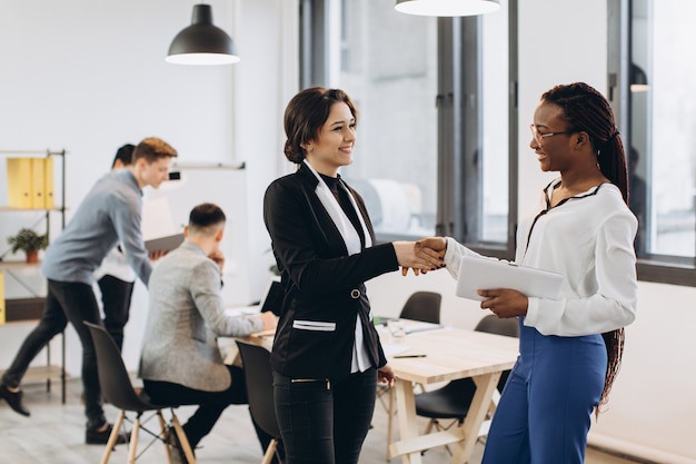 African and Caucasian businesswomen have handshakes on modern office