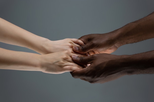 African and caucasian hands gesturing