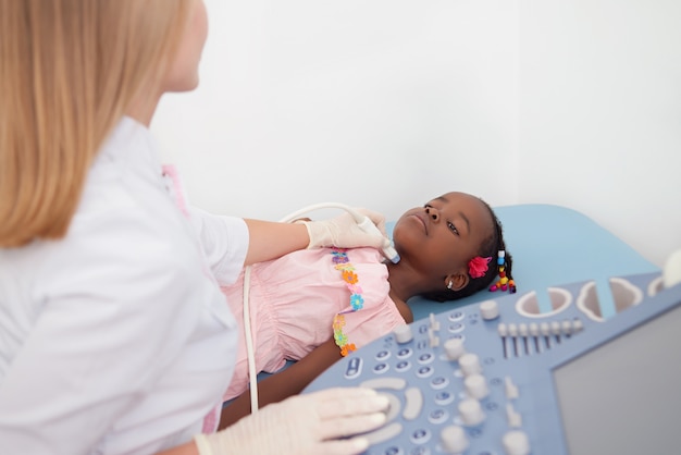 African child during ultrasound of thyroid at hospital.