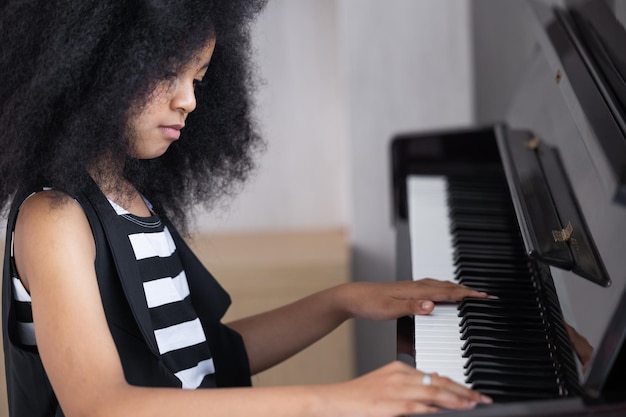 Foto i bambini africani si divertono imparando a suonare lo strumento musicale del pianoforte