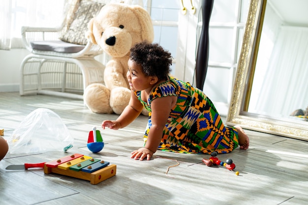 Foto la ragazza dei bambini africani vive con la sua famiglia in soggiorno. il giocattolo femminile dell'africa felice con sua sorella.