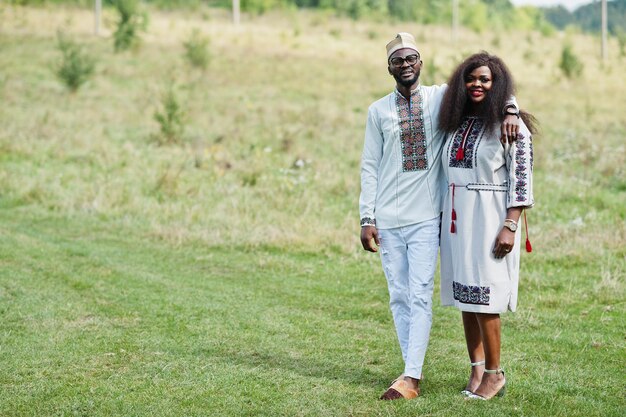 African couple in traditional clothes at park.