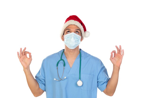 白い背景で隔離コロナウイルスの時間にクリスマスの帽子をかぶってアフリカの医師