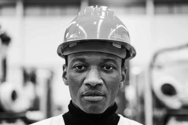 African engineer working inside robotic factory Focus on face Black and white editing
