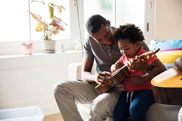 アフリカの父親の教育息子のギターの演奏方法