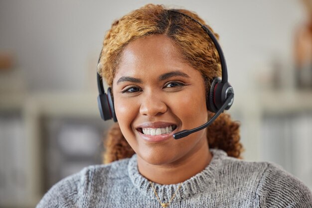 アフリカの女性のコールセンターエージェントは笑顔で仕事で彼女のオフィスを手伝って幸せです彼女の職場でクライアントをサポートする準備ができて興奮している若い女性のカスタマーサービス従業員の肖像