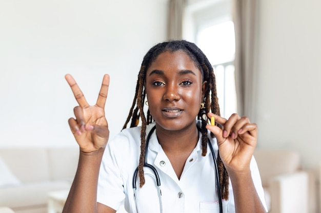 African female doctor talking while explaining medical treatment to patient through a video call with laptop in the consultation