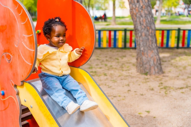 An african girl playing on a slide