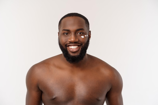 African handsome man applying cream on his face mans skin care concept