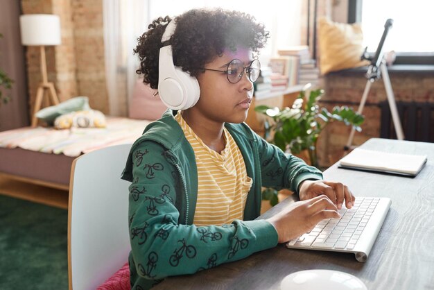 Photo african kid using computer for online game