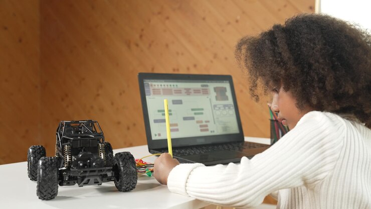 Photo african kid writing car model structure while laptop display code erudition