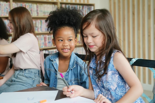 Bambini africani che disegnano e fanno i compiti in classe giovane ragazza felice studio divertente a scuola