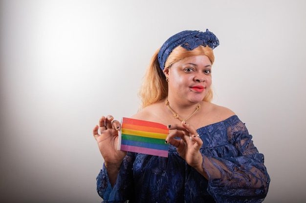 Foto lesbica africana in posa con la bandiera arcobaleno è vestita con un ritratto in studio di vestiti africani