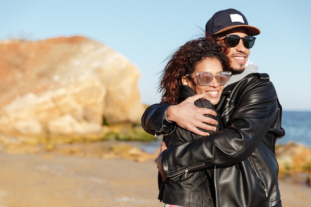 African loving couple walking outdoors at beach.