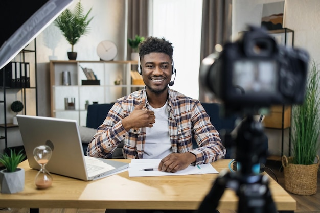 African male blogger in headset recording video on camera