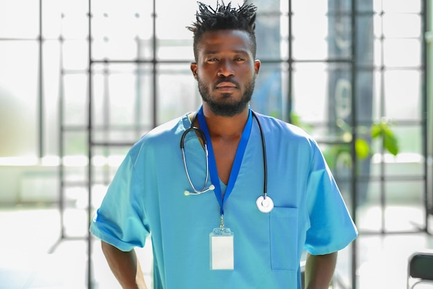 African male doctor wearing medical coat standing in hospital corridor