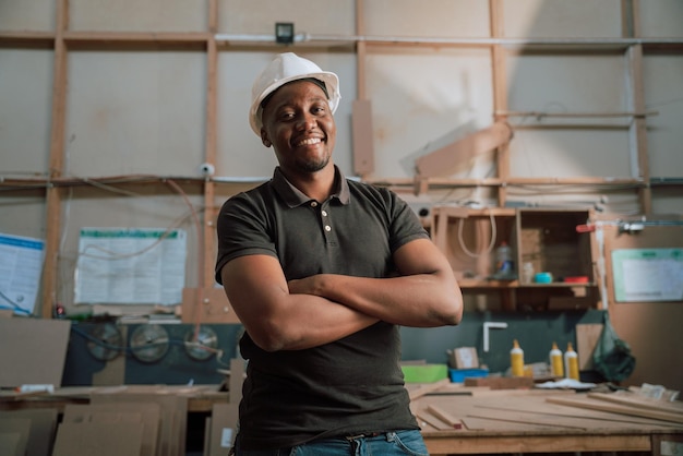 African male happy confident trainee carpenter supervisor at work in factory