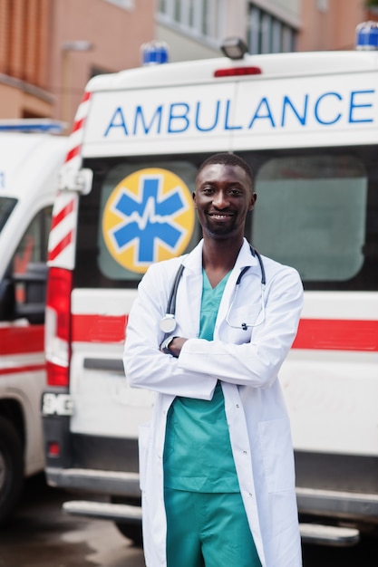 African male paramedic standing in front of ambulance car 