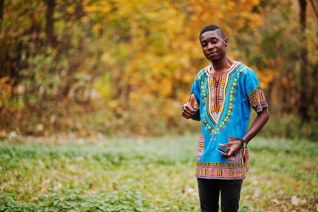 Uomo africano in camicia tradizionale africa sul parco autunnale