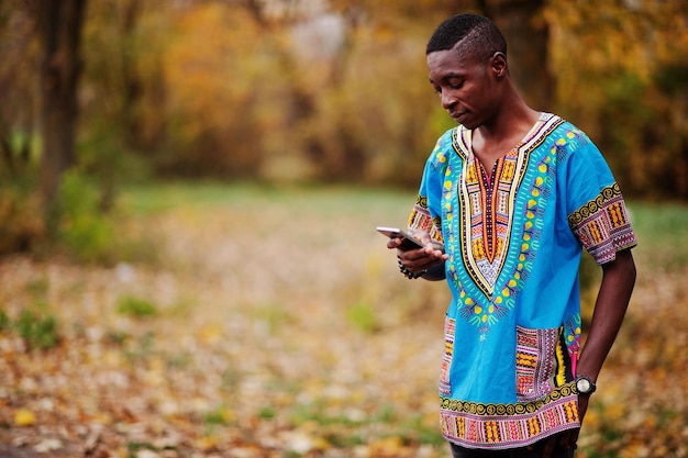 African man in africa traditional shirt on autumn park