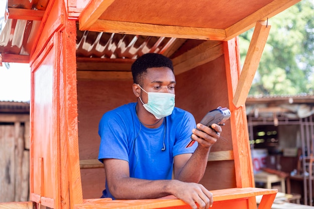 African man holding POS-terminal in the shop