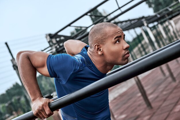 Photo an african man is exercising at open air gym