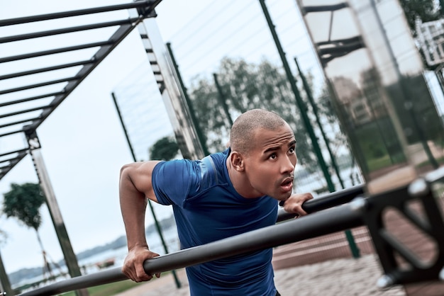 Photo an african man is exercising at open air gym