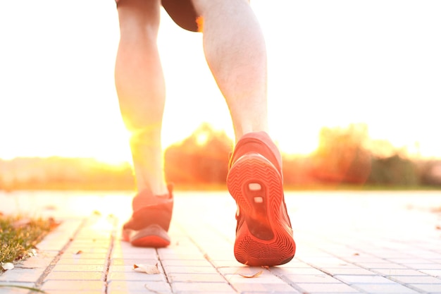 African man legs running while exercising outdoors, at sunrise or sunset.