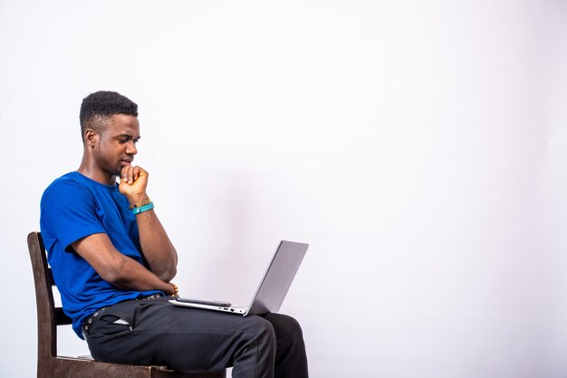 African man looking puzzled while using his laptop