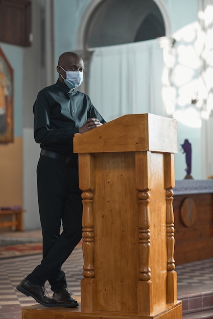 African man in mask performing during mass in the church