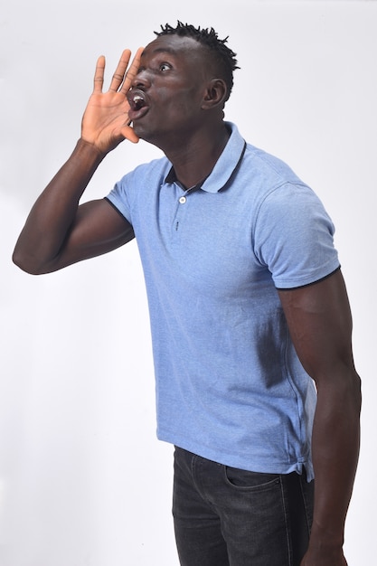 African man putting a hand in mouth and is screaming on white background