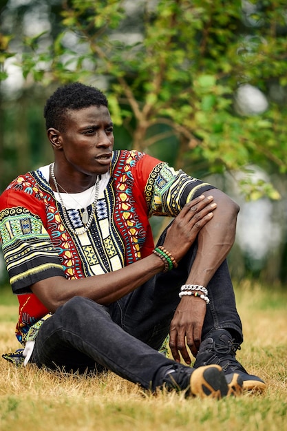 An African man in South African national clothes a black young man resting in a park in national clothes