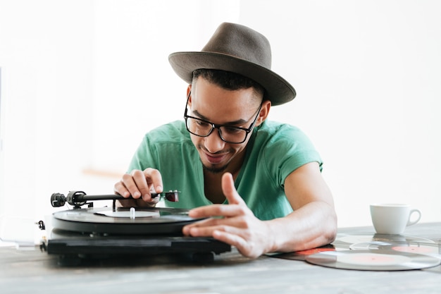 African man in t-shirt using record-player