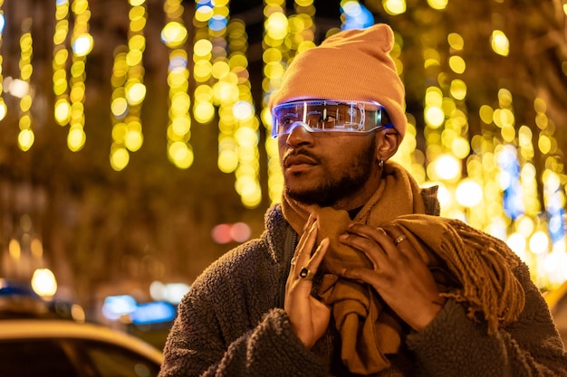 African man wearing smart glasses during a Christmas city night
