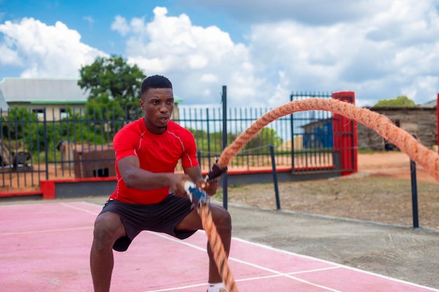 African Men with battle rope battle ropes exercise in the fitness gym