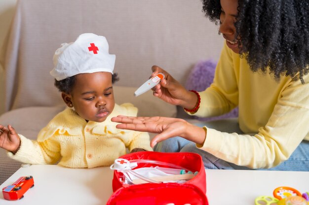 African mother and daughter playing doctors at home