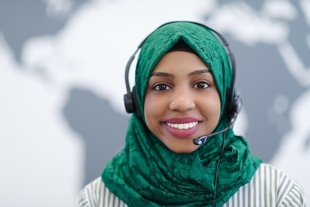 African muslim female with green hijab scarf customer representative business woman with phone headset helping and supporting online with customer in modern call centre