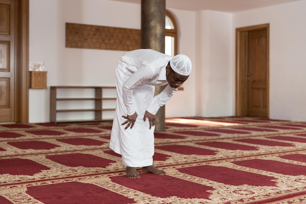 African Muslim Man Making Traditional Prayer To God While Wearing A Traditional Cap Dishdasha