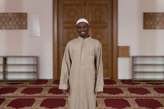 African Muslim Man Making Traditional Prayer To God While Wearing A Traditional Cap Dishdasha